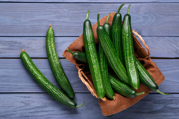 Basket with fresh cucumbers on grey wooden background