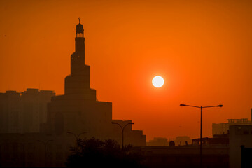 The silhouette Al Fanar tower mosque during the beautiful sunset in Doha, Qatar.