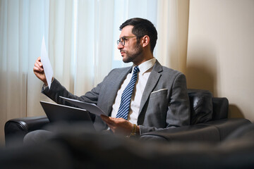 Man in business suit and glasses is studying working documents