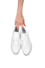 White leather female sneakers in hands isolated on white background. Fashionable stylish sports casual shoes.