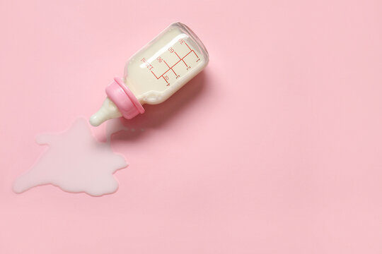 Bottle of milk for baby on pale pink background