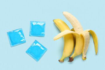 Bananas with condoms on blue background. Sex concept