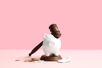 Broken piggy bank with judge gavel and money on pink background. Bankruptcy concept