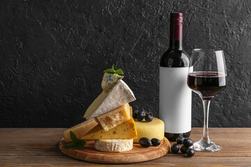 Different tasty cheese, glass and bottle with wine on table