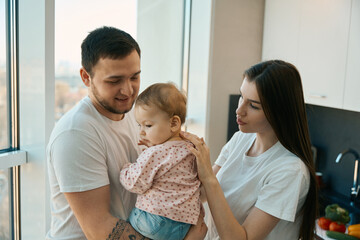 Happy young mom and dad are happy communicate with daughter