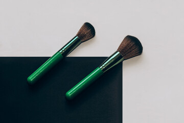Green makeup brushes on a wooden table.