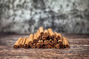 Close-up of ceylon cinnamon sticks on wooden table, rustic style still life. Natural food of sri-lankan cinnamon for poster or banner. Delicious tasty healthy concept. Copy advertising text space - obrazy, fototapety, plakaty