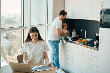 Caring father babysits baby in the kitchen