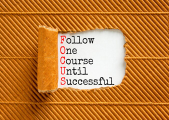 FOCUS follow one course until successful symbol. Concept words FOCUS follow one course until successful on white paper. Brown background. Business FOCUS follow one course until successful concept.
