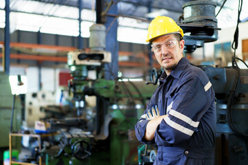 Smart and good looking senior factory or mechanical engineer standing in the factory portrait, caucasian white male engineer or foreman portrait in factory.