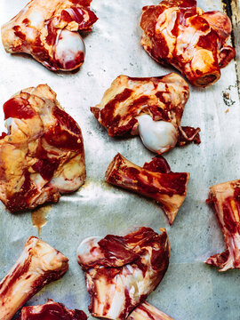 Uncooked beef bones on a roasting tray being prepped for making stock