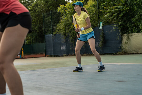 Two competitive female tennis players engage in an intense match, their swift movements and powerful strokes showcasing their dedication and love for the sport.