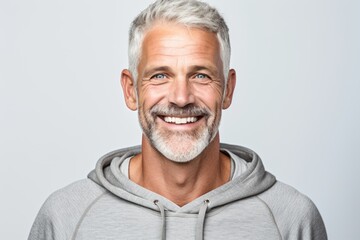 Fototapeta premium Close-up portrait photography of a grinning mature man wearing soft sweatpants against a white background. With generative AI technology