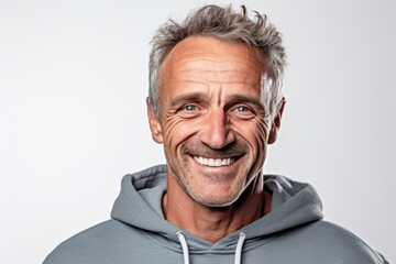 Obraz premium Close-up portrait photography of a grinning mature man wearing soft sweatpants against a white background. With generative AI technology
