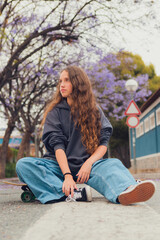 Obraz premium Young woman poses with a skate on the road of a street