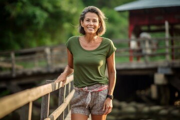 Environmental portrait photography of a satisfied mature woman wearing breezy shorts against a rustic bridge background. With generative AI technology