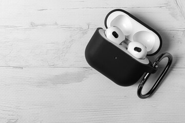 wireless headphones in black case on wooden background.