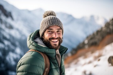 Fototapeta na wymiar Conceptual portrait photography of a happy boy in his 30s wearing a warm beanie against a serene snow-capped mountain background. With generative AI technology