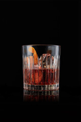 elegant glass of Bourbon Old Fashioned, on black background.