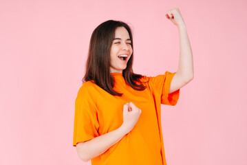 Triumphant Elation: Young Woman with Exuberant Expression, Raised Fists, Celebrating Success in...