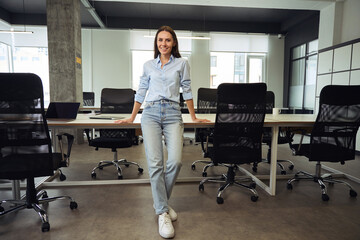 Fototapeta premium Happy company employee posing for camera in modern workplace
