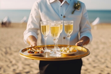 Waiter at a party, carrying a tray with champagne or wine glasses. Outdoor wedding, party on the beach, Generative AI