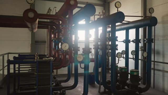 Hot steam transporting system with pipelines and compressors in mechanical room. Heat generating technology of boiler house. Pumping equipment
