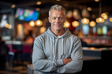 Fototapeta premium Lifestyle portrait photography of a satisfied mature man wearing soft sweatpants against a lively sports bar background. With generative AI technology