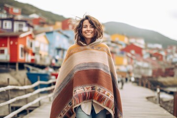 Lifestyle portrait photography of a joyful girl in her 30s wearing a unique poncho against a picturesque fishing village background. With generative AI technology