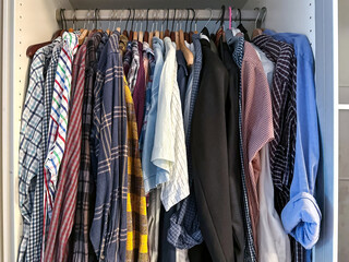 Wardrobe with shirts hanging on row in home