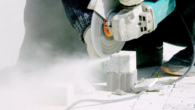 Man city worker cuts paving slab with tile cutting saw crop body. Cutting process performed accurately avoiding material breakage