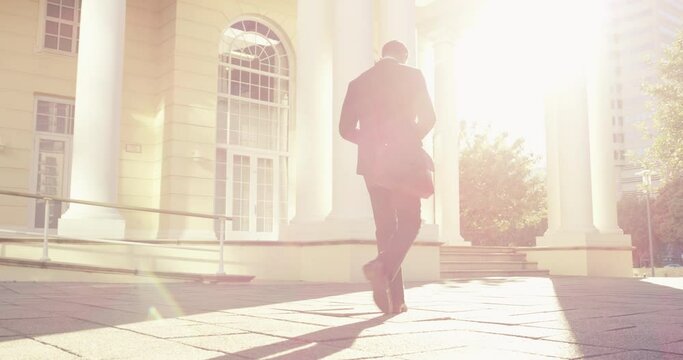 City business man, back and walking to office building, corporate job or work in morning travel commute. Lens flare, sunshine or urban person, attorney or lawyer on commuting journey in Washington DC