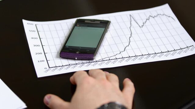 Incoming message received on manager mobile phone in meeting. Man takes cell phone in hand and checks message information crop body