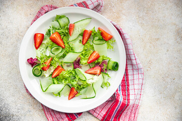 strawberry salad cucumber, lettuce healthy meal food snack on the table copy space food background rustic top view 