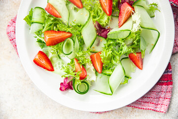 strawberry salad cucumber, lettuce healthy meal food snack on the table copy space food background rustic top view 