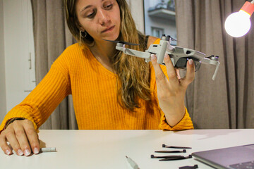 girl repairing her drone at home