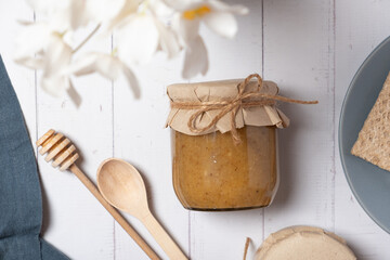 Glass jar with nuts honey on wooden background top view, flat lay on wooden background.