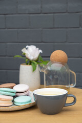 Buckwheat tea in a cup and macarons on the table in the cafe. Sweet food Still life