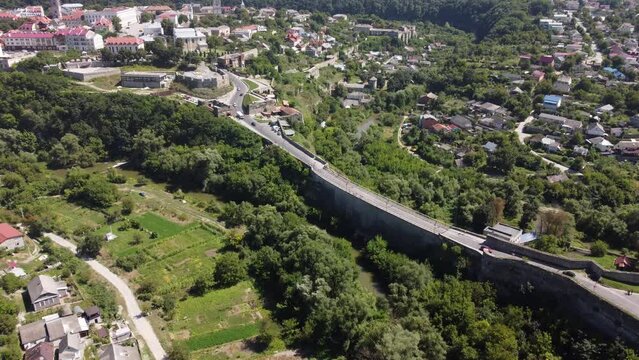 Aerial drone high view of city of Kamenets-Podolsky in Ukraine. Kamianets-Podilskyi cityscape with concrete bridge through green canyon to castle. Flying over the historical old town in Europe.