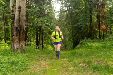 woman jogging on a trail in a natural forest park