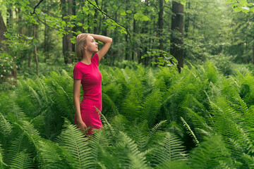 beautiful girl in the spring forest among the ferns
