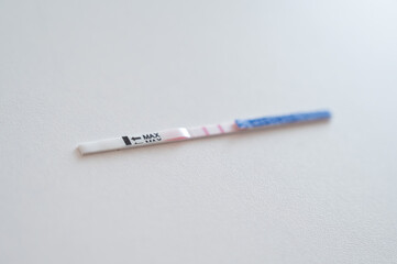 Positive home express pregnancy test on a white table. The long-awaited two stripes.