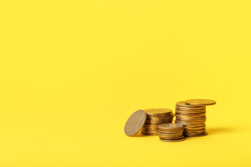 Stacks of coins on yellow background