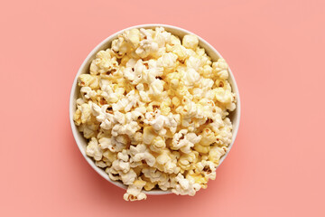 Bowl with crispy popcorn on pink background