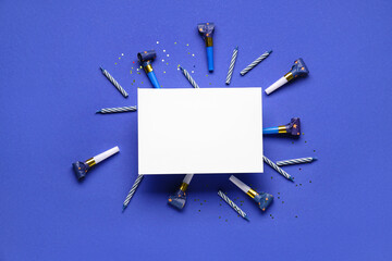 Frame made of different party decor with greeting card on dark blue background