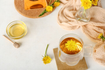 Obraz na płótnie Canvas Glass cup of healthy dandelion tea on white table