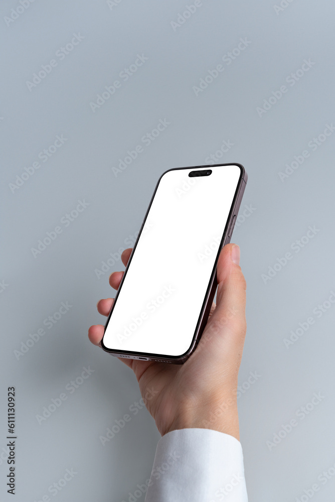 Poster hand holds a smartphone with blank, isolated screen against a grey background. isolated screen for m