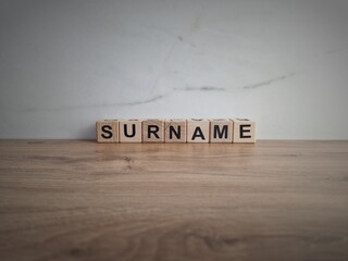 Word surname from wooden blocks on desk