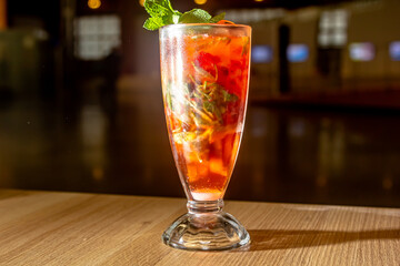 refreshing summer cocktail drink lemonade with ice, lime, strawberries tarragon glass close up