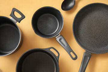 Cooking pots and frying pan on beige background